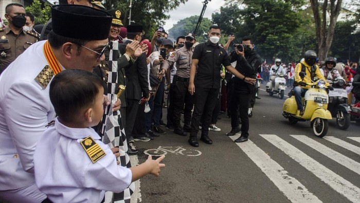 Gubernur Jawa Barat Ridwan Kamil bersama anaknya melihat pawai skuter usai upacara peringatan HUT Ke-77 Kemerdekaan Republik Indonesia di Lapangan Gasibu, Bandung, Jawa Barat, Rabu (17/8/2022). Gubernur Jawa Barat sebagai inspektur upacara menyampaikan momen peringatan kemerdekaan tahun ini menjadi momentum bangkit kembali menuju Jabar Juara dan Indonesia Juara. ANTARA FOTO/Novrian Arbi/rwa.