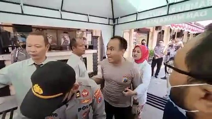 Kasat Lantas Polres Madiun AKP Dwi Jatmiko dipegang istrinya saat cekcok dengan wartawan di mapolres