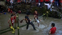 Dua orang warga saling memukul menggunakan bantal saat mengikuti lomba pukul bantal di kanal Kecamatan Manggala, Makassar, Sulawesi Selatan, Minggu (14/8/2022). (Abriawan Abhe/Antara)