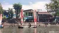Warga saling adu ketangkasan saat lomba kepruk guling. Siapa yang bertahan di atas sebilah bambu, dia yang menang.