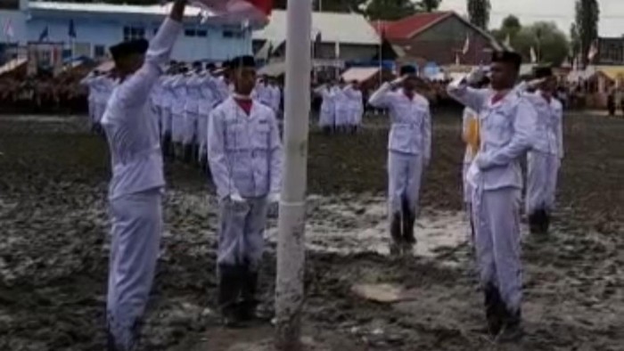 Paskibra di Bone melangsungkan upcara di lapangan berlumpur.