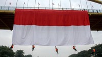 Pengibaran bendera merah putih ini dilakukan dengan cara terjun menggunakan tali dari jembatan tersebut.(Rony Muharrman/Antara Foto)