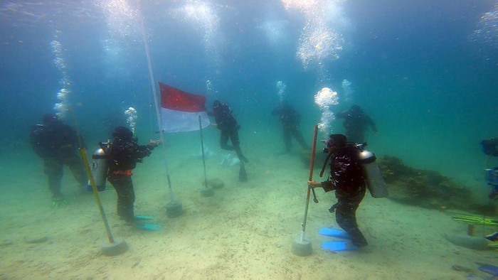Pengibaran bendera merah putih dengan inspektur upacara Danlantamal XIV Laksamana Pertama TNI Imam Musani dilaksanakan di dasar laut Pulau Matan Kabupaten Raja Ampat, Papua Barat, Rabu (17/8/2022). Sesuai perintah KASAL, Laksamana TNI Yudo Margono, pengibaran bendera merah putih di dasar laut serentak dilakukan di 77 lokasi sebagai isyarat bahwa TNI AL siap menjaga kedaulatan dan keamanan di laut. ANTARA FOTO/Olha Mulalinda/hp.