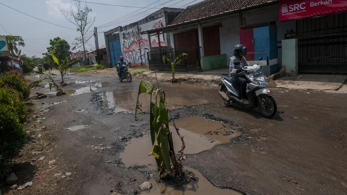 Protes Jalan Rusak, Warga Tanam Pohon di Tengah Jalan Pengendara roda dua melintas dijalan yang rusak di Kolelet, Lebak Banten, Rabu (17/8/2022). Penanaman pohon pisang di jalan penghubung Kabupaten Serang dan Kabupaten Lebak tersebut dilakukan warga setempat sebagai bentuk protes karena jalan rusak yang tidak kunjung diperbaiki oleh pemerintah daerah. ANTARA FOTO/Muhammad Bagus Khoirunas/rwa.
