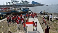 Sejumlah anak dan relawan komunitas Kelas Jurnalis Cilik mengikuti upacara bendera dalam rangka hari ulang tahun (HUT) ke-77 Republik Indonesia di pesisir Cilincing, Jakarta, Rabu (17/8/2022).