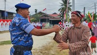 Prajurit TNI AU, Serda Nurhadi menyalami warga usai Upacara HUT ke-77 RI di Komplek Trans Jasa Industri di Pekanbaru. (Raja Adil Siregar/detikSumut)