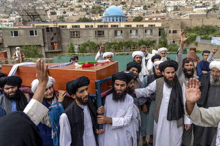 Taliban fighters and local residents gather around a mosque that has been bombed, in Kabul, Afghanistan, Thursday, Aug. 18. 2022. A bombing at a mosque in Kabul during evening prayers on Wednesday killed at least 10 people, including a prominent cleric, and wounded over two dozen, an eyewitness and police said. (AP Photo/Ebrahim Noroozi)