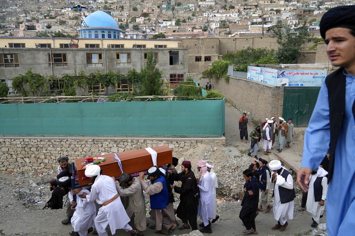 Afghanistan Taliban fighters and local residents gather around a mosque that has been bombed, in Kabul, Afghanistan, Thursday, Aug. 18. 2022. A bombing at a mosque in Kabul during evening prayers on Wednesday killed at least 10 people, including a prominent cleric, and wounded over two dozen, an eyewitness and police said. (AP Photo/Ebrahim Noroozi)