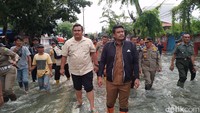Bobby berjalan kaki menyusuri genangan air yang ada di Jalan Dr Masnyur. Bobby menyebut banjir di kawasan ini terjadi akibat luapan Sungai Selayang  (Farid Achyadi Siregar/detikSumut)