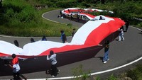 Bendera sepanjang 77 meter itu dibawa untuk dipasang mengelilingi patung Yesus tertinggi di dunia yang ada di Tana Toraja.  