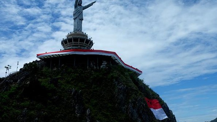 TANA TORAJA, INDONESIA - AUGUST 17: Environment activists raise the Indonesian flag with a length of 77 meters around the tallest Jesus statue in the world with a height of 1,700 meters above sea level in Tana Toraja, South Sulawesi, Indonesia, Wednesday 17 August 2022. The 77-meter flag raising ceremony was held to commemorate the 77th Independence Day of Indonesia. (Photo by Zul Kifli/Anadolu Agency via Getty Images)