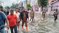 Memakai sepatu boots orange, Bobby terlihat serius meninjau lokasi banjir di Jalan Dr Mansyur Medan. (Farid Achyadi Siregar/detikSumut)