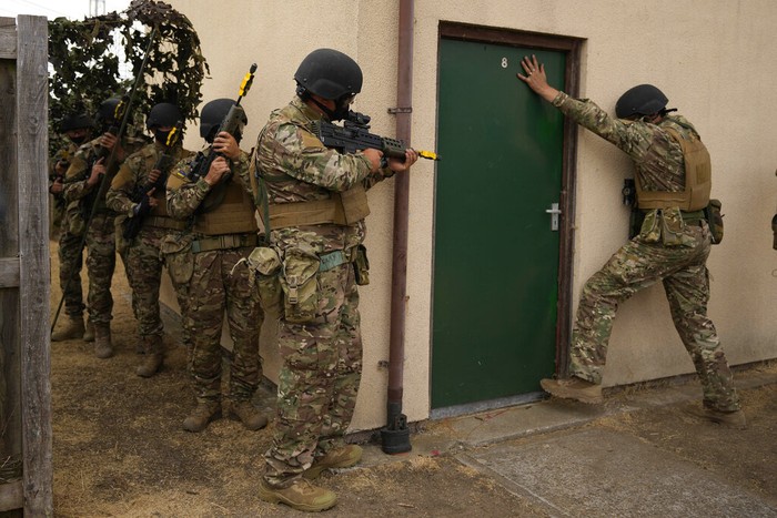 A used smoke grenade sits on the tarmac as Ukrainian volunteer military recruits take part in an urban battle exercise whilst being trained by British Armed Forces at a military base in Southern England, Monday, Aug. 15, 2022. MOD and British Army as the UK Armed Forces continue to deliver international training of Ukrainian Armed Forces recruits in the United Kingdom.(AP Photo/Frank Augstein)
