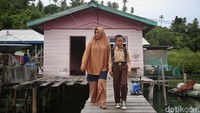 Renalto (11) berjalan dengan ibunya, Rika (32), keluar dari rumahnya di Desa Telaga Kecil, Kabupaten Kepulauan Anambas, Kepulauan Riau, Rabu (3/8/2022).  