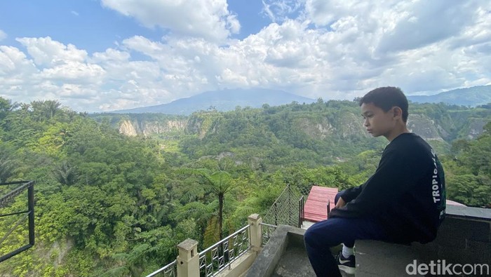 Seorang warga saat menikmati pemandangan yang ada di Ngarai Sianok. (Jeka/detikSumut)