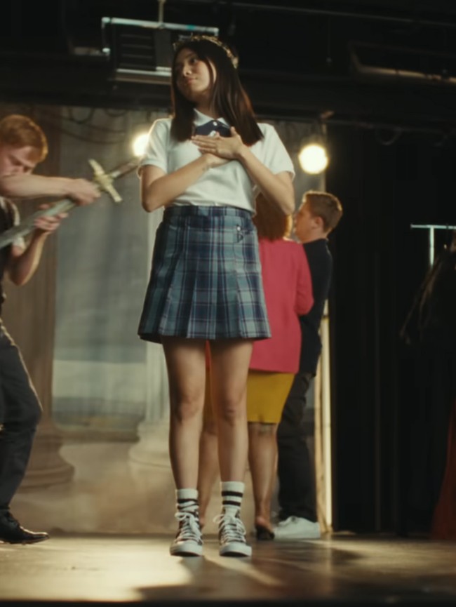 Dalam video tersebut, wanita 23 tahun ini mengenakan kemeja putih, dasi silang dan rok tartan. Tampak dalam video, ia memilih suasana SMA di sekolah internasional. Foto: YouTube