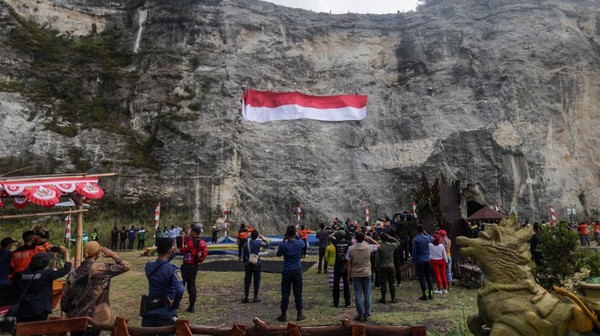 Atlet panjat tebing Kabupaten Bogor mengibarkan bendera merah putih di Gunung Kapur, Kawasan Wisata Goa Lalay, Klapanunggal, Kabupaten Bogor, Jawa Barat, Rabu (17/8/2022). (Yulius Wijaya/AntaraFoto)