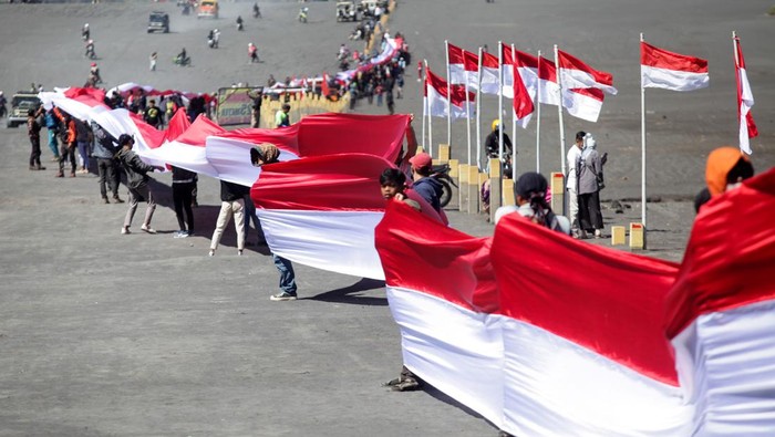 Potret Pengibaran Bendera Merah Putih di Sejumlah Gunung Puluhan pengunjung membentangkan bendera Merah Putih sepanjang 2022 meter di Kawasan Gunung Bromo, Probolinggo, Jawa Timur, Rabu (17/8/2022). Kain yang terbagi dalam sejumlah potongan dan disatukan menjadi bendera Merah Putih raksasa sepanjang 2022 meter tersebut dibentangkan untuk memperingati HUT ke-77 kemerdekaan RI. ANTARA FOTO/Umarul Faruq/rwa.