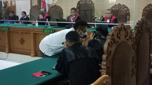 Terdakwa suap DID yang juga mantan staf khusus eks Bupati Tabanan Ni Putu Eka Wiryastuti, Dewa Nyoman Wiratmaja (kiri) berkoordinasi dengan penasihat hukumnya usai pembacaan jawaban JPU atas nota pembelaan dalam sidang yang berlangsung pada Kamis (18/8/2022).