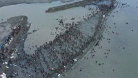 Foto udara ini menunjukkan abrasi pantai yang rusak akibat terjangan air laut. Respon pemerintah yang lambat membuat warga secara sukarela memperbaiki tanggul yang rusak untuk menghentikan banjir.  