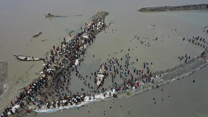 Warga Bangladesh Gotong Royong Perbaiki Tanggul Bocor KHULNA, BANGLADESH - AUGUST 17: Coastal people volunteer to work re-mending a damaged embankment that was damaged three times in a month in the coastal area in Khulna, Bangladesh on August 17, 2022.
Due to climate change, again rising tides collapsing the embankments of coastal areas of Bangladesh, flooded and saltwater entering the locality damaging crops, and fish and hampered livelihood. (Photo by Zakir Hossain Chowdhury/Anadolu Agency via Getty Images)