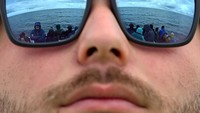 Refleksi para traveler di kacamata saat menunggu ikan paus melintas. Berbagai spesies paus dan banyak burung laut hidup di teluk terbesar di Islandia itu.  