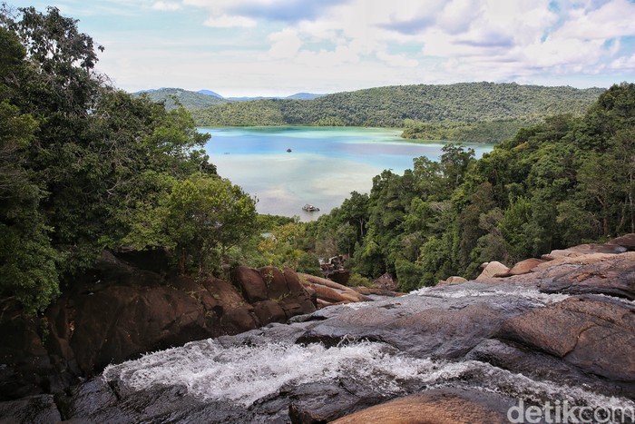Pengendara motor melintas di depan Air Terjun Temburun di Pulau Siantan, Kabupaten Kepulauan Anambas, Kepulauan Riau, Selasa (2/8/2022). Kepulauan Anambas menyimpan beragam destinasi wisata yang menarik untuk dikunjungi. Tidak heran bila kabupaten termuda di Provinsi Kepulauan Riau ini kerap dijuluki surga kecil di perbatasan Indonesia.