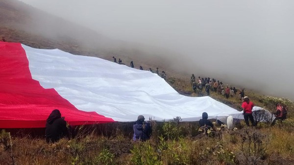 Sesampainya di puncak dengan ketinggian 2.423 MDPL dari jalur Doroncanga, para peserta melakukan kegiatan upacara dan pengibaran bendera raksasa yang dipimpin oleh Kepala Balai TN Tambora, Yunaidi. (dok. Istimewa)