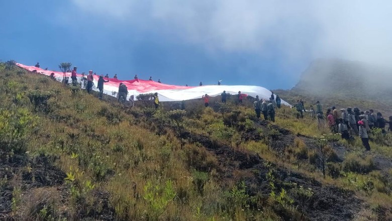 Bendera merah putih raksasa berkibar di puncak Gunung Tambora Peserta upacara pengibaran bendera raksasa di lereng Gunung Tambora