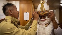 Salah satu anggota Taruna bersiap-siap memakai kostum tarian anoman untuk tampil di atas kapal KRI Bima Suci-945 di dermaga Lanal Tual di Tual, Maluku, Kamis (18/8/2022).