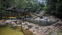 Pengunjung duduk di tepian kolam alam di wisata Air Terjun Neraja di Kabupaten Kepulauan Anambas, Kepulauan Riau, Sabtu (6/8/2022). 