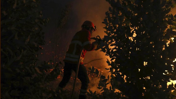 A firefighter works to put out a forest fire in the Rio Maior area in Portugal, Wednesday, Aug. 17, 2022. (AP Photo/Joao Henriques)