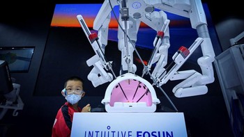 Seorang anak melihat lengan robot untuk operasi medis.