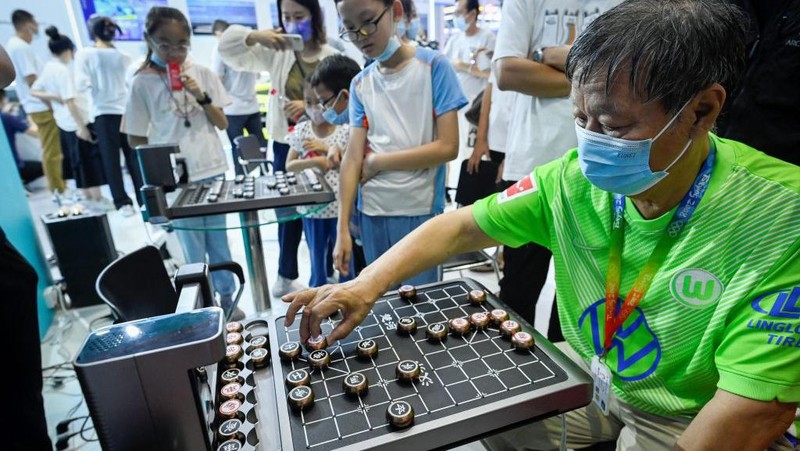 A man plays Chinese chess with a robot at the 2022 World Robot Conference in Beijing on August 18, 2022. (Photo by WANG Zhao / AFP) (Photo by WANG ZHAO/AFP via Getty Images)