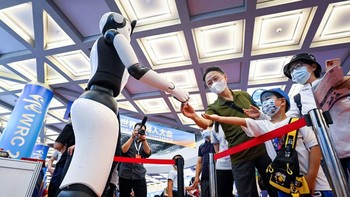 Sebuah robot berjabat tangan dengan pengunjung Konferensi Robot Dunia 2022. Konferensi yang digelar secara hybrid yaitu online dan offline ini mencakup tiga acara utama: forum, fair dan kompetisi.