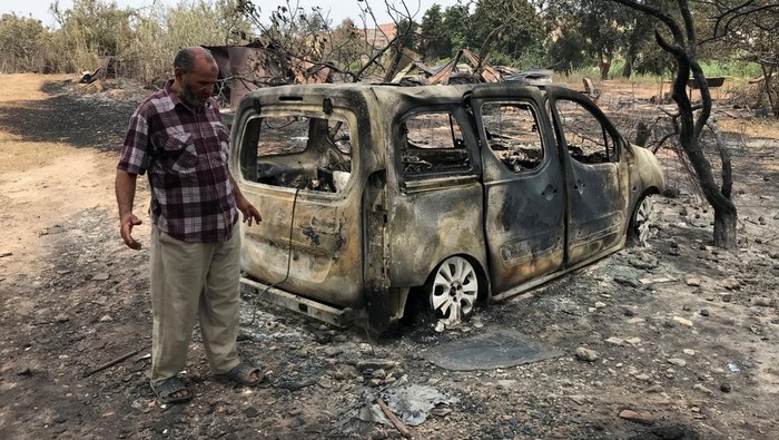 Mobil-mobil Ini Jadi Bangkai Gegara Kebakaran Hutan di Aljazair Men inspect a bus that was burnt following a wildfire in El Kala, in Al Taref province, Algeria August 18, 2022. REUTERS/Ramzi Boudina