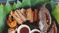 Menu makanan di sini, disajikan di atas nampan kayu, dengan lapisan daun pisang. Lauk dikelilingi dengan aneka sambal segar.  Foto: Pool/Site