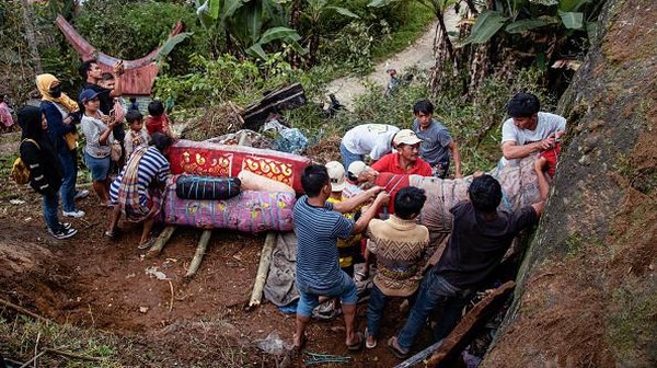 Penduduk menarik peti mati dari gua pemakaman Desa Torea di Toraja Utara, Sulawesi Selatan. Gua itu diukir di lereng gunung dalam ritual untuk kehidupan setelah kematian.
