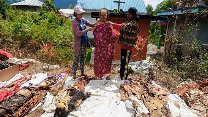 Ritual Ganti Baju Orang Mati di Tana Toraja Bikin Merinding TOPSHOT - This picture taken on August 17, 2022 shows a family member of the Toraja ethnic group preparing the bodies of exhumed relatives from a community burial site to be cleaned and dressed in a series of traditional ceremonies honouring the dead known as