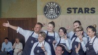 Anggota staf berpose untuk foto pada peluncuran kedai kopi baru Stars Coffee.