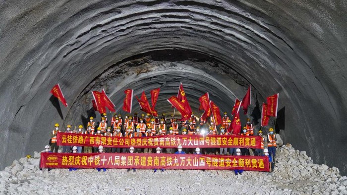 Terowongan Kereta cepat Guiyang-Nanning Mulai Beroperasi Akhir 2023 HECHI, CHINA - AUGUST 17: Workers celebrate the breakthrough of the Jiuwandashan No. 4 tunnel on Guiyang-Nanning high speed railway on August 17, 2022 in Hechi, Guangxi Zhuang Autonomous Region of China. The tunnel was drilled through on Wednesday. The Guiyang-Nanning high speed railway is expected to start operation at the end of 2023 with a designed speed of 350 kilometers per hour. (Photo by Wang Yizhao/China News Service via Getty Images)