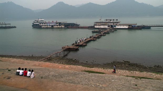 CHINA - 2009/06/05: Boats harbouring on the Yantze River at Yichang, the first major city downstream from the Three Gorges Dam. The world's largest electricity-generating plant, the dam spans the length of the Yangtze River after it has passed through the Three Gorges. It was built to serve three purposes: electricity, increase the river's navigation capacity and reduce the potential for floods, which have claimed 350,000 lives in the last 200 years alone. 
First envisaged by Sun Yat-sen in 1919, the dam only began construction in 1994. It finished filling this year, in 2009.
 The dam has sparked tremendous controversy, flooding a reported 8,000 archaeological and cultural sites, displacing 1.25 million people (official figures - lobby groups place figures up to 50% more than this), and causing significant ecological changes, including an increased risk of landslides, sediment buildup and erosion. Riddled with corruption, a week after the dam started filling, in 2002, cracks appeared on the dam wall. 
If broken, the resulting surge of water could wipe out the city of Yichang. (Photo by Leisa Tyler/LightRocket via Getty Images)
