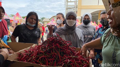 Emak-emak membeli cabai merah di pasar murah.