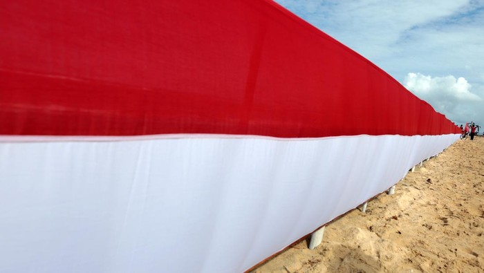 HUT RI, Bendera 100 Meter Dibentangkan di Pulau Kapuk Peserta gowes merah putih mengangkat sepeda untuk melewati bendera merah putih di pantai wisata pulau Kapuk, Lhoknga, Aceh Besar, Aceh, Sabtu (20/8/2022). Dalam rangka memeriahkan HUT ke-77 kemerdekaan Republik Indonesia, Kodam Iskandar Muda menyelenggarakan gowes merah putih sejauh 17 kilometer dan mengibarkan bendera merah putih sepanjang 100 meter di pantai wisata Aceh Besar. ANTARA FOTO/Irwansyah Putra/foc.