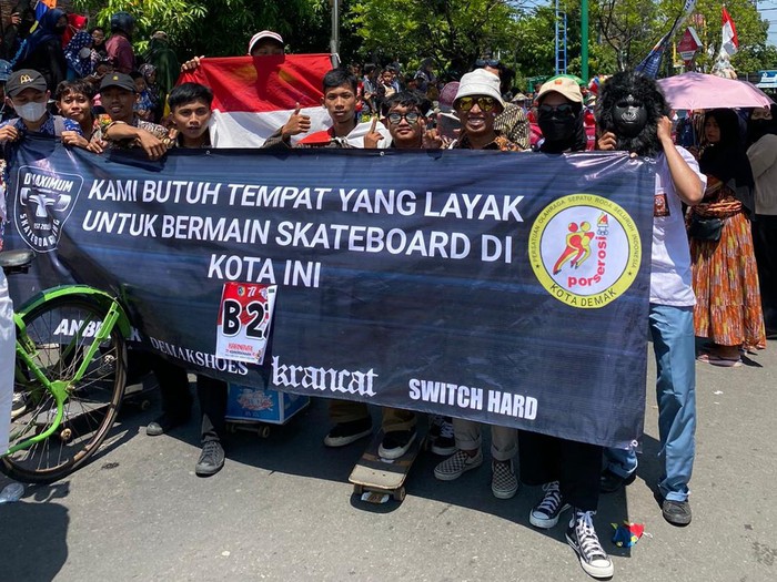 Para skater muda di Demak membentangkan spanduk tuntutan di sela mengikuti karnaval kemerdekaan, Sabtu (20/8/2022) siang.