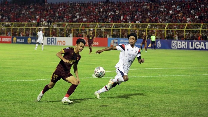 Pemain Muda PSM Dzaki Asraf mencoba melewati Kapten Arema FC Johan Alfarizi.