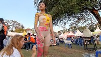 Salah satu seniman dari luar negeri membuat lukisan tubuh (body painting) dalam acara Sanur Village Festival 2022. Foto: I Wayan Sui Suadnyana