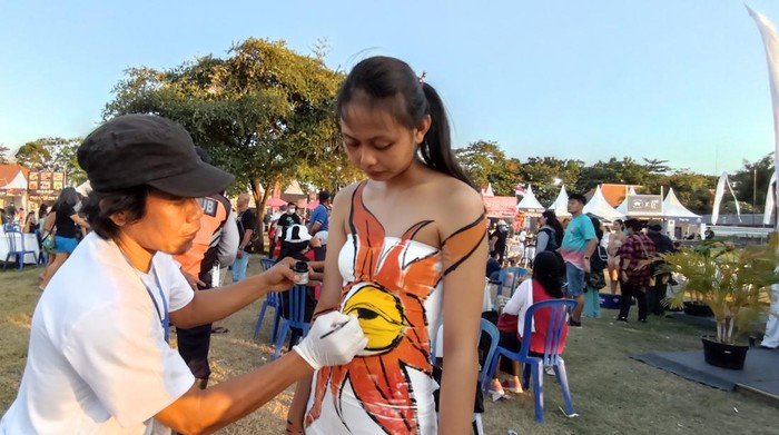 Seniman I Wayan Wirawan tengah melukis tubuh (body painting) di Sanur Village Festival.
