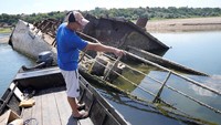 Seorang nelayan menunjukkan bangkai kapal era Perang Dunia II tersebut.