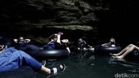Sejumlah wisatawan tampak menyusuri gua menggunakan ban. Sebagian dari mereka juga mengabadikan suasana di dalam gua.